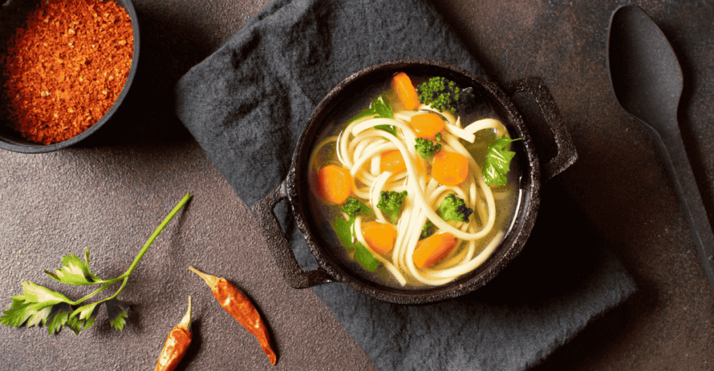 A pot of Chicken Noodle Soup simmering on the stovetop