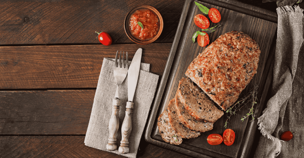 Close-up of a sliced meatloaf with perfectly seasoned ground beef.
