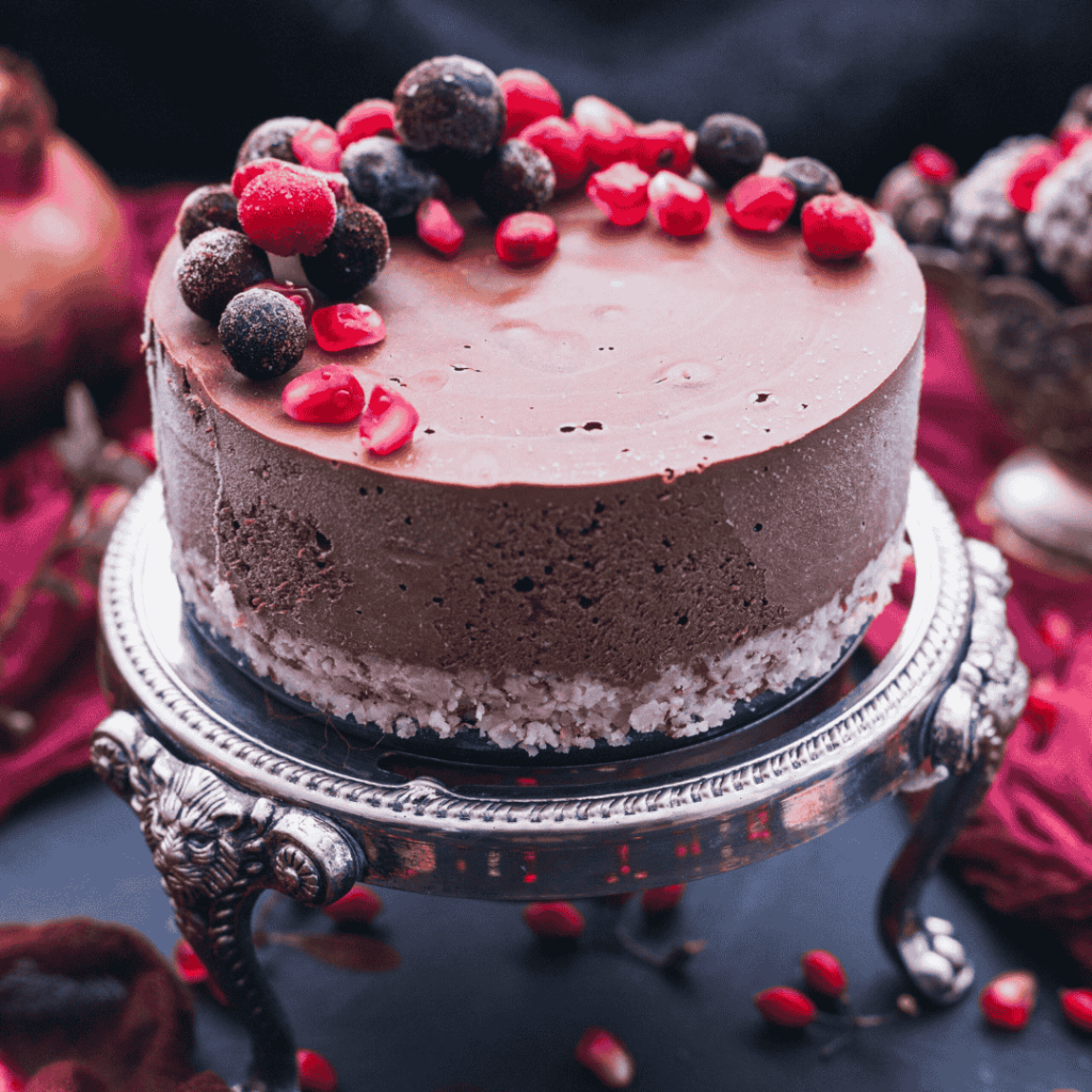 Sweet chocolate cake with pomegranate seeds and fresh berries on it