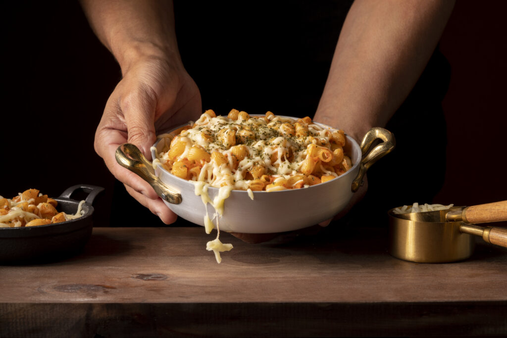 A creamy bowl of mac and cheese topped with crispy breadcrumbs.
