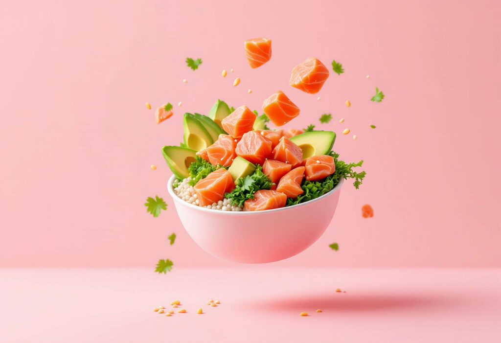 A close-up shot of salmon cubes, avocado, cucumber, and rice in a poke bowl.
