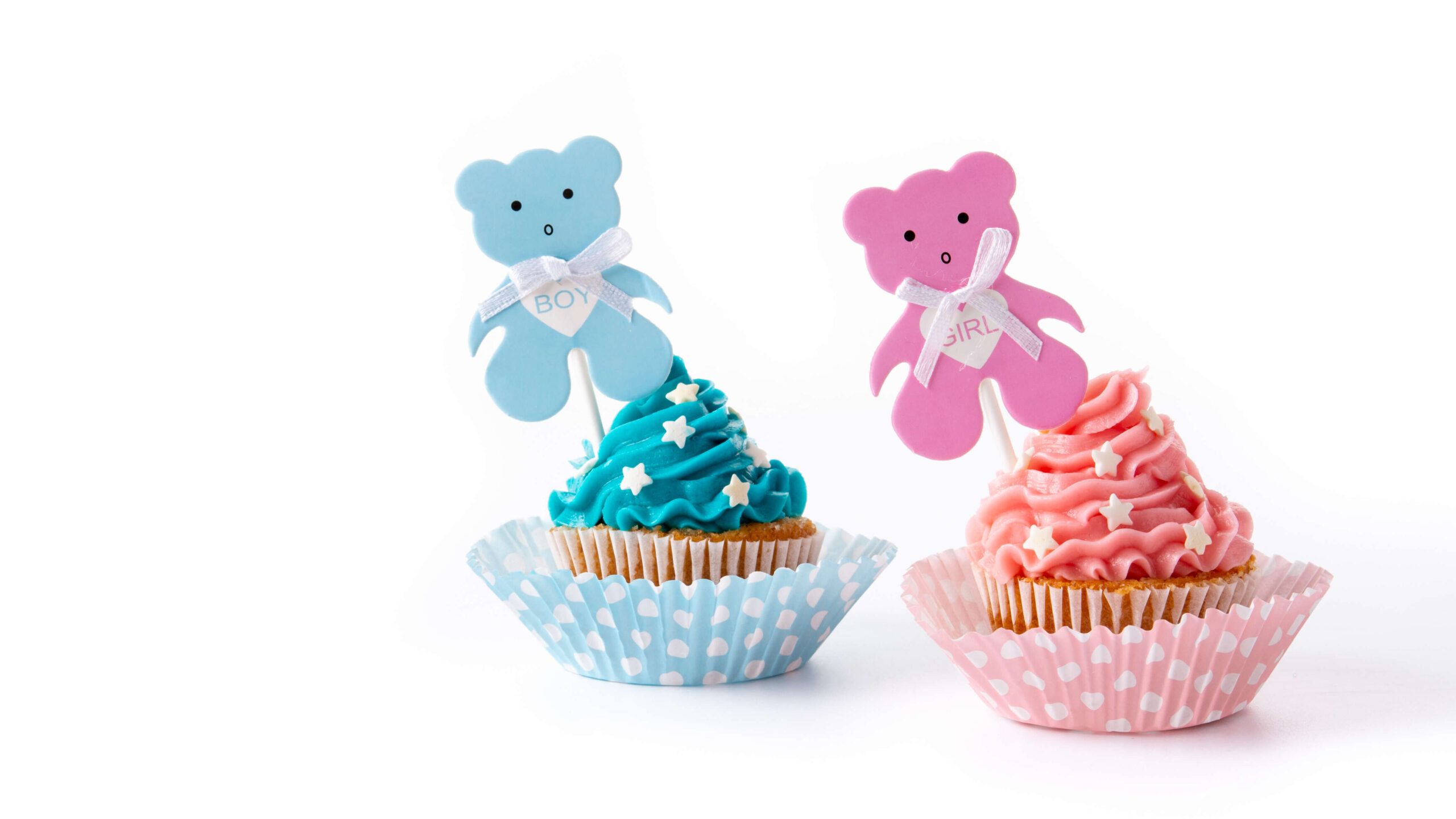 A close-up of colorful gender reveal cupcakes, featuring pink and blue frosting with a small gender reveal decoration on top.