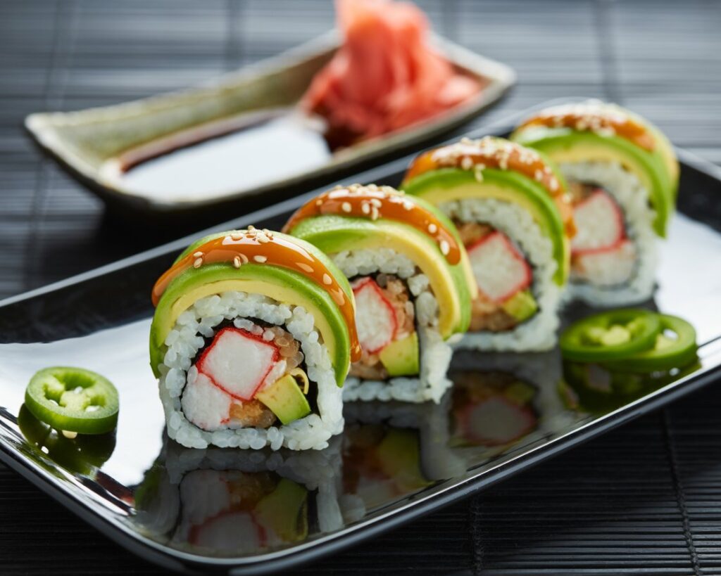 Spicy California rolls garnished with sriracha and green onions