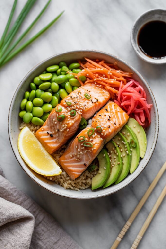 Bowl filled with salmon chunks, edamame, carrots, and cabbage