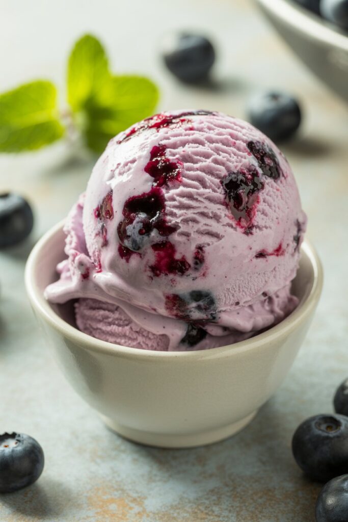 Ice cream scoop with creamy blueberry ice cream on waffle cone