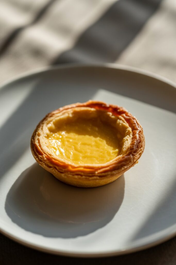 Delicious egg tarts served on a plate with golden flaky pastry