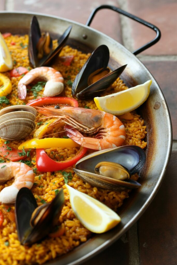 Mediterranean style paella with golden rice seafood and vegetables in a large pan