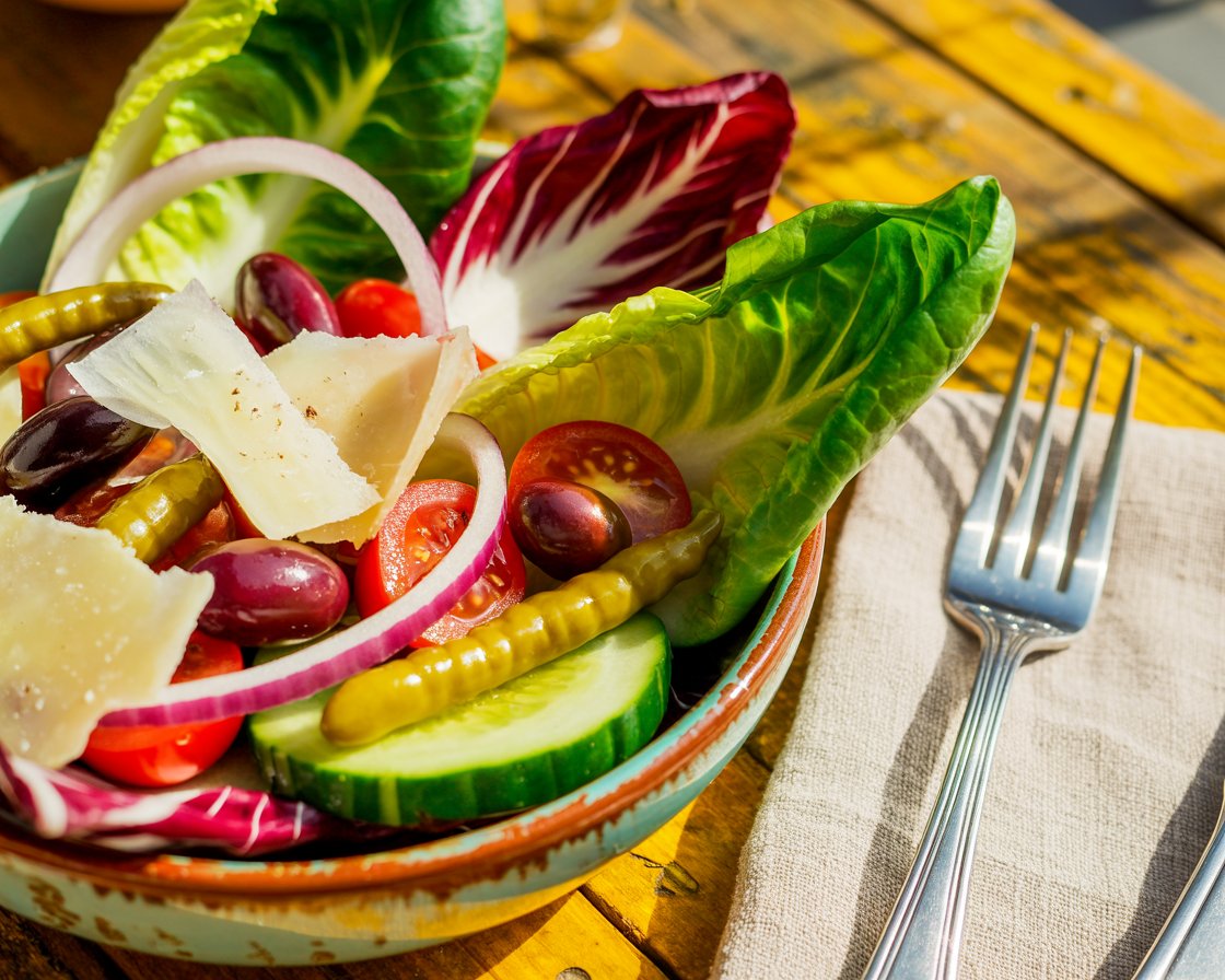 Close-up of colorful Italian salad drizzled with olive oil.